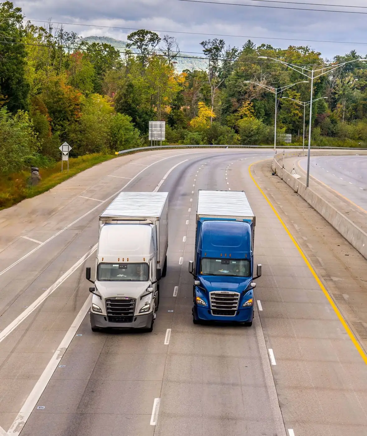 Two semi trucks driving on a highway