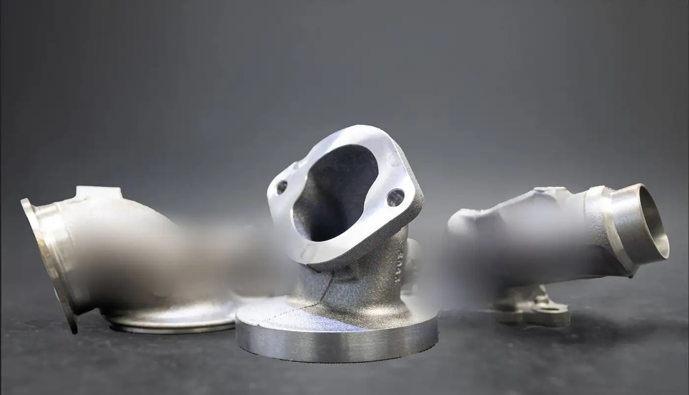 Three machined cast iron elbows on a dark background