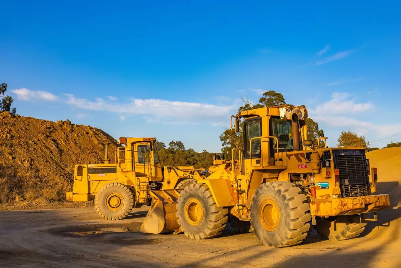Wheel loaders working at a quarry at golden hour