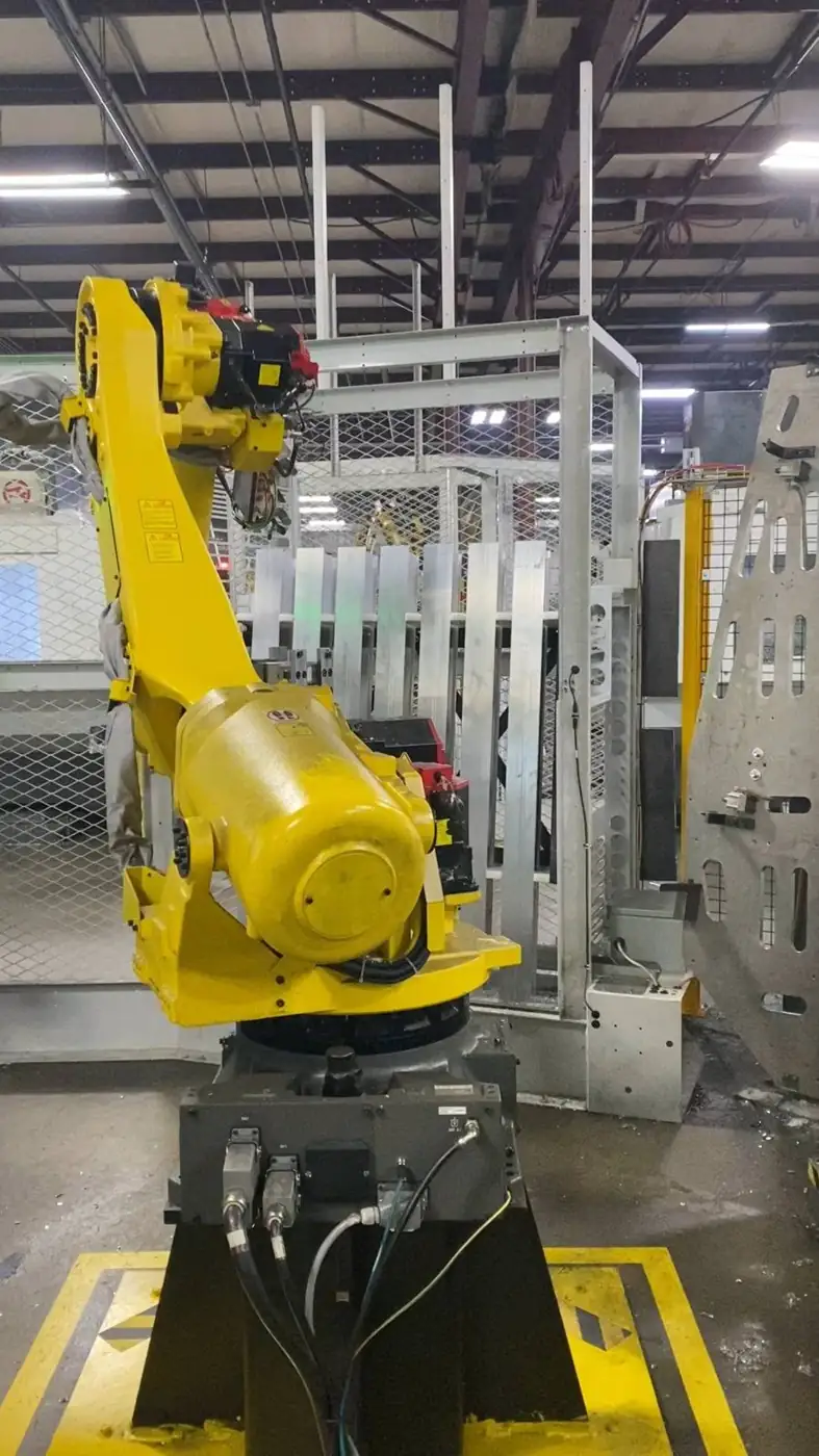 Industrial robot in a guarded cell handling aluminum extrusions