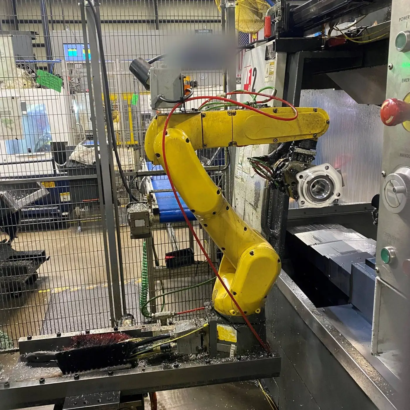 Robot tending a CNC lathe inside a guarded cell