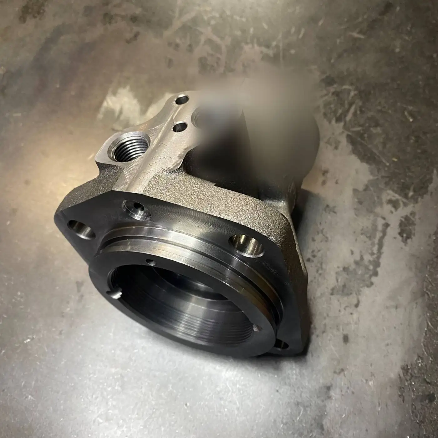 Machined iron housing with threaded ports
